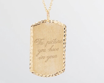 May include: Gold necklace with a rectangular pendant that has the inscription "The picture you have in your" engraved on it.