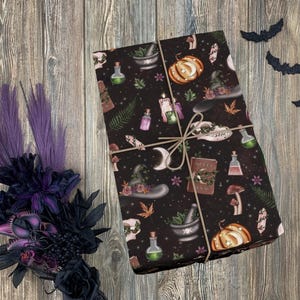May include: Black and brown wrapping paper with a witchy theme. The paper features a repeating pattern of potion bottles, a witch's hat, a cauldron, a book, a pumpkin, and other witchy elements.