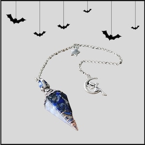May include: A blue and white crystal pendulum with a silver chain and a silver charm of a fairy on a crescent moon. The chain has a silver star charm.