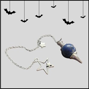 May include: A silver chain with two star charms and a lapis lazuli pendulum. The pendulum is a dark blue, round stone with a silver tip.