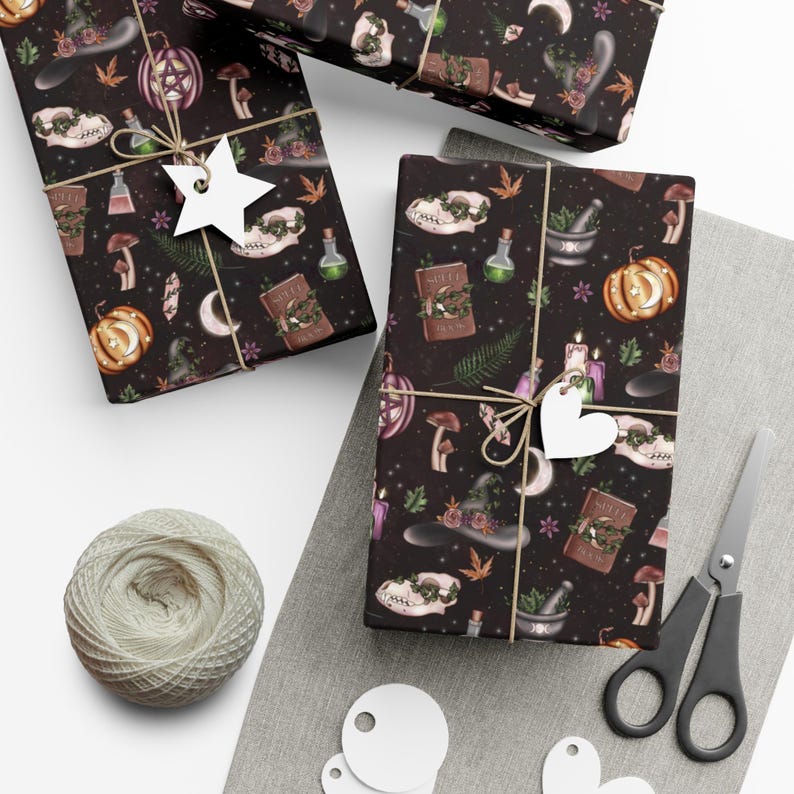 May include: Black and white wrapping paper with a witchy theme. The paper features a repeating pattern of skulls, potion bottles, mushrooms, pumpkins, and other witchy items. The paper is wrapped around a gift box and tied with twine.