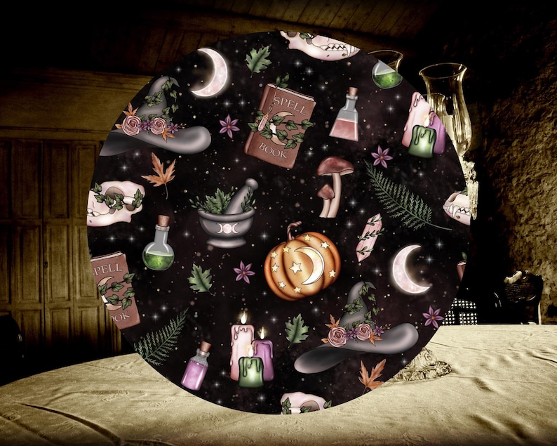 May include: A black and white round tablecloth with a witchy theme. It features a variety of illustrations including a witch's hat, a cauldron, a spell book, a pumpkin, and a crescent moon. The tablecloth has a dark background with a starry pattern.