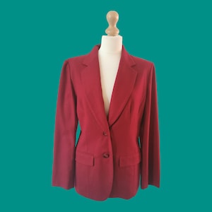 Könnte beinhalten: Ein roter Blazer mit einreihiger Knopfleiste und zwei Pattentaschen.