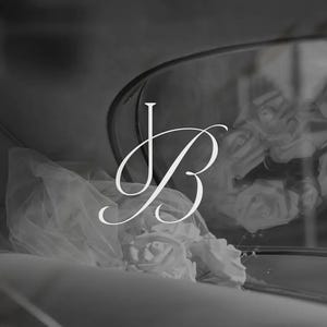 May include: Monochrome image featuring a stylized JB monogram in elegant script. A veil and roses are visible, suggesting a wedding or bridal theme. The overall aesthetic is soft and romantic, with a focus on delicate details.