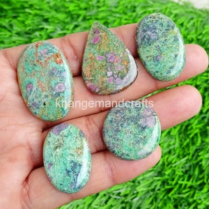 May include: Five green and pink gemstone cabochons with a mottled pattern. The cabochons are oval and teardrop shaped.