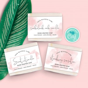 May include: Three white soap bars with pink watercolor designs and black text. The soap bars are labeled "Sandalwood and vanilla", "Sweet citronella", and "Strawberry sensation". Each bar has the text "Hand Crafted Soap", "Cold Pressed", "100% Organic", and "Vegan".