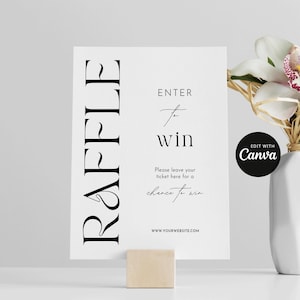 以下が含まれることがあります： 縦にスタイリッシュなフォントで「RAFFLE」と書かれた白い看板。看板には「ENTER to win」と「Please leave your ticket here for a chance to win」の文字も書かれている。看板の下部にはウェブサイトのアドレス「WWW.YOURWEBSITE.COM」が記載されている。