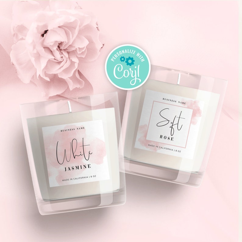 May include: Two glass candle jars with labels. The candle on the left is labeled "White Jasmine" and the candle on the right is labeled "Soft Rose". Both candles are made in California and are 8 oz.