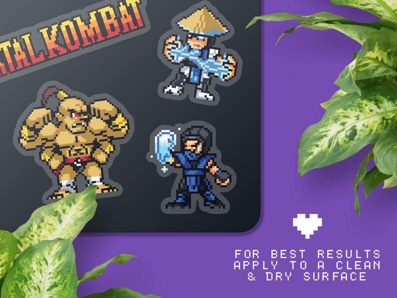May include: Pixel art stickers featuring characters from Mortal Kombat. The stickers include a large red and orange Mortal Kombat logo, and pixelated images of three characters in various action poses. The text at the bottom says "FOR BEST RESULTS APPLY TO A CLEAN & DRY SURFACE."