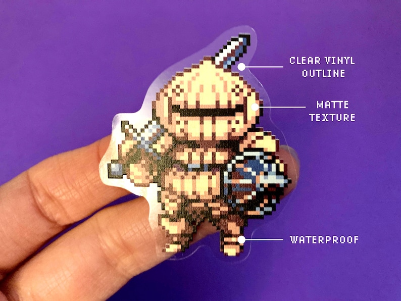May include: A clear vinyl sticker with a matte finish featuring a pixelated illustration of a knight in armor holding a sword and shield. The sticker is waterproof.