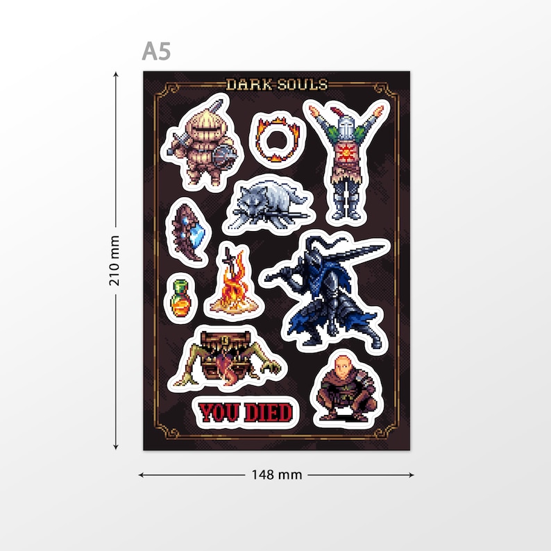 May include: A sheet of Dark Souls themed stickers featuring characters, items, and the iconic "You Died" message. The stickers are printed on a black background with a gold border. The sheet measures 148 mm by 210 mm.