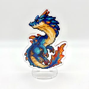 May include: A pixelated dragon figurine in shades of blue, orange, and yellow, standing on a clear acrylic base. The dragon has a detailed, retro video game aesthetic. The figurine is a decorative item.