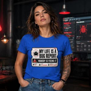 May include: A woman wearing a blue t-shirt with the text "MY LIFE IS A BUG REPORT, NOBODY IS FIXING IT". The shirt has a graphic of a bug and a warning sign. She is in a tech-themed environment.