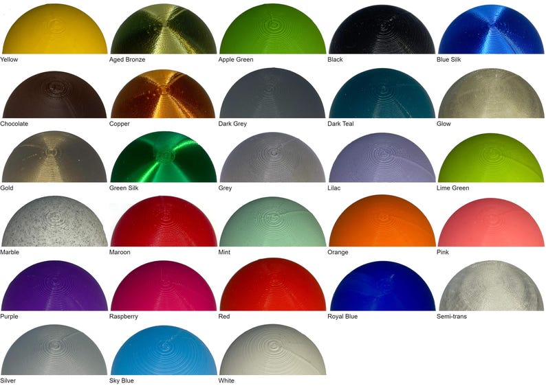 May include: A selection of semi-spherical objects in a range of colours, such as yellow, black, blue, red, and green. Each object has a textured surface and is labelled with its colour name.