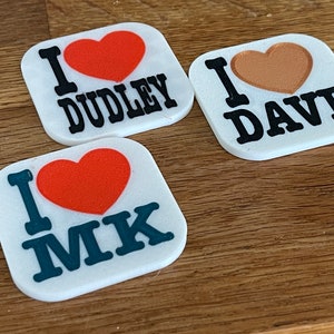 Può includere: Tre calamite quadrate bianche con le scritte «I DUDLEY», «I DAVE» e «I MK». Ogni calamita presenta un cuore rosso o marrone e lettere nere o verde acqua.