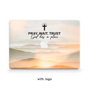 May include: A laptop skin featuring a soft, hazy landscape of layered mountains in shades of orange, peach, and cream. The text PRAY. WAIT. TRUST God has a plan is printed in black above a cross icon and a central white Apple logo cutout.