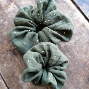 May include: Two green fabric hair scrunchies with gold glitter dots.