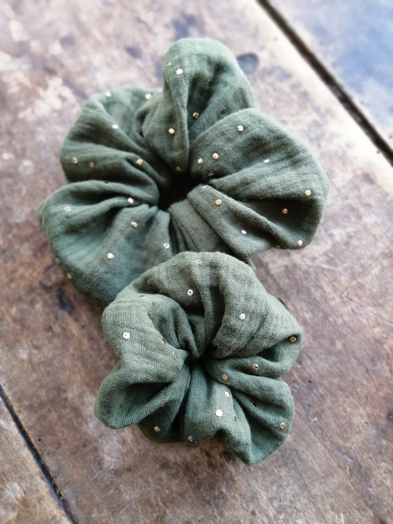 May include: Two green fabric hair scrunchies with gold glitter dots.