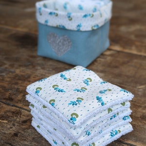 Lot de 12 lingettes format 8 x 8 cm en microfibre et coton imprimé fleurs vertes sur fond écru. Elles sont rangées dans un panier en lin vert avec un coeur pailleté .  Il mesure 9 cm de côté environ.