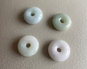 May include: Four jade donut beads, two are light green and two are white.