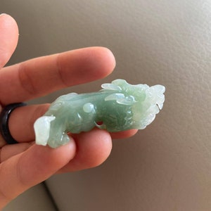 May include: A green jade carving of a dragon, a traditional Chinese symbol of good luck and prosperity.