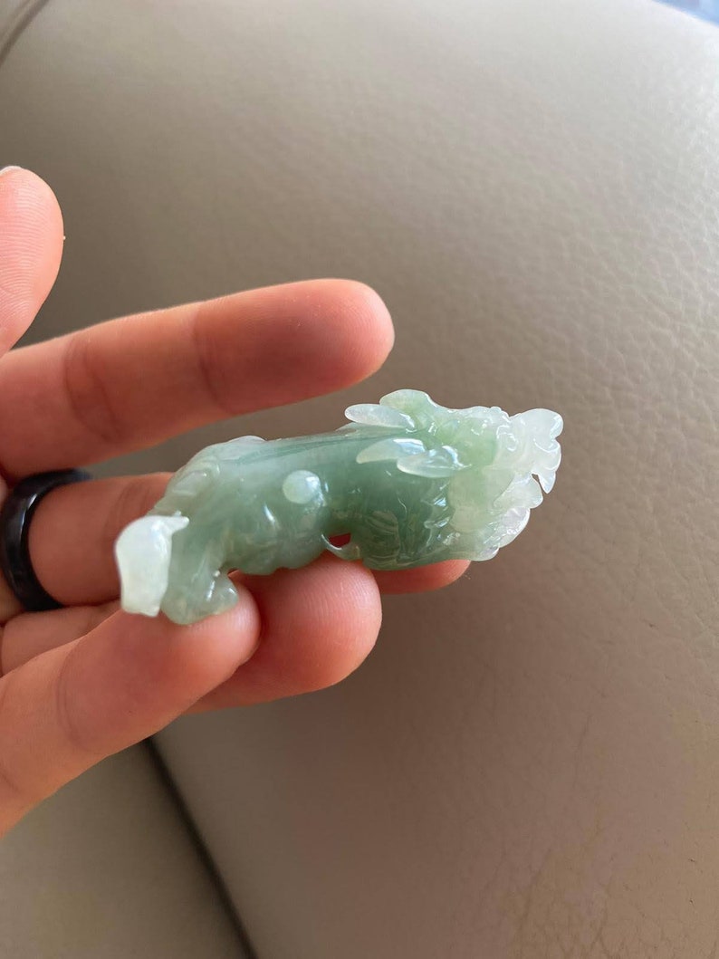 May include: A green jade carving of a dragon, a traditional Chinese symbol of good luck and prosperity.
