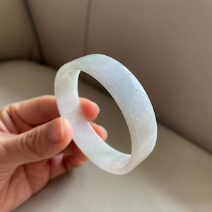 Peut inclure: Un bracelet en jade blanc avec un motif de tourbillon vert subtil.