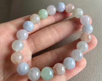 May include: A bracelet made of round, pastel-colored beads. The beads are a mix of light blue, pink, and green.