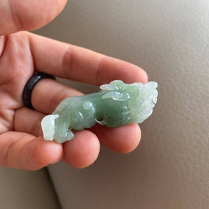 May include: A green jade carving of a dragon, a traditional Chinese symbol of good luck and prosperity.