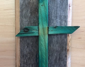 Asymmetrical coastal cross stained in warm green made from pallet wood.