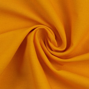 Könnte beinhalten: Nahaufnahme eines glatten, gelben Stoffes mit einer weichen, strukturierten Oberfläche. Der Stoff ist gefaltet und drapiert und erzeugt einen sanften, fließenden Effekt.