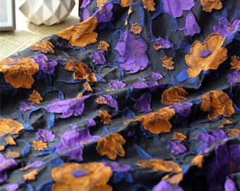 Peut inclure: Un tissu noir avec un motif floral en relief. Les fleurs sont violettes, orange et bleues.