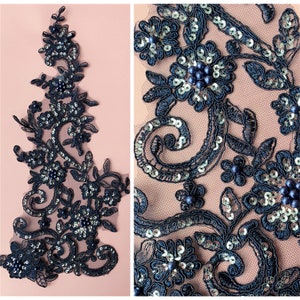 Puede incluir: Aplique de encaje negro con lentejuelas plateadas y cuentas negras. El aplique presenta un diseño floral con detalles intrincados.