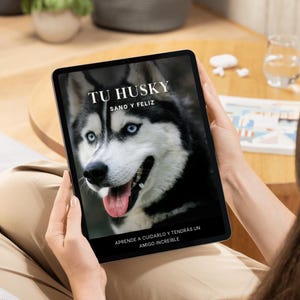 Puede incluir: Una tableta mostrando la portada de un libro con un perro husky. La portada se titula "Tu Husky Sano y Feliz" y tiene el texto "Aprende a cuidarlo y tendras un amigo increible".