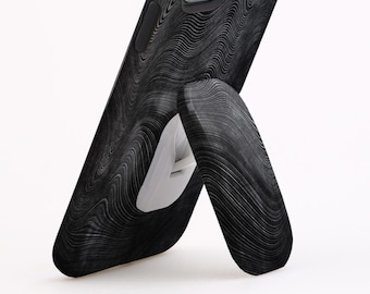 May include: A black phone case with a wood grain pattern and a built-in kickstand. The phone case is designed to prop up the phone for hands-free viewing.