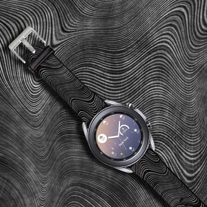 May include: A black smartwatch with a black patterned band on a black and white wavy background.