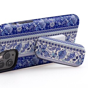 Puede incluir: Una funda para teléfono de patrón azul y blanco con un soporte desplegable. La funda tiene un diseño de cachemira y el texto "USE IT IN LANDSCAPE MODE TO WATCH VIDEOS".