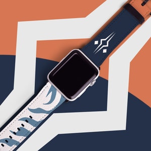 May include: A white Apple Watch with a blue and white patterned band. The band has a geometric design with a white background and blue accents.