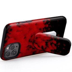 Könnte beinhalten: Eine rote und schwarze Handyhülle mit einem integrierten Ständer. Die Hülle hat ein marmorartiges Muster und der Text "USE IT IN LANDSCAPE MODE TO WATCH VIDEOS" ist sichtbar.