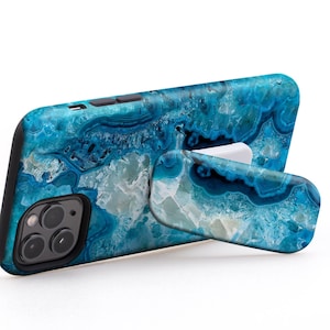 Könnte beinhalten: Eine blaue und weiße Achat-Handyhülle mit integriertem Ständer. Die Hülle hat einen schwarzen Rand und einen Kameraausschnitt. Der Text "USE IT IN LANDSCAPE MODE TO WATCH VIDEOS" ist im Bild sichtbar.