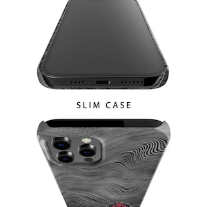 May include: A black phone case with a wood grain pattern and a black camera lens cover. The case is designed to fit a phone with a triple camera system. The case has a slim design and is made of durable material.