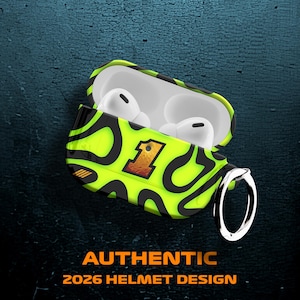 Könnte beinhalten: Geöffnete AirPod-Hülle mit einem limettengrünen und schwarzen Muster und der Zahl 1. Enthält weiße AirPods. Ein silberner Ring ist angebracht. Der Text "AUTHENTIC 2026 HELMET DESIGN" ist unten zu sehen.