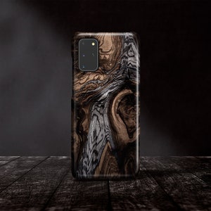 May include: A black phone case with a wood grain pattern. The case has a camera cutout on the back.