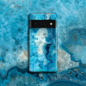 Puede incluir: Una funda para teléfono de ágata azul y blanca con un recorte de cámara negro.