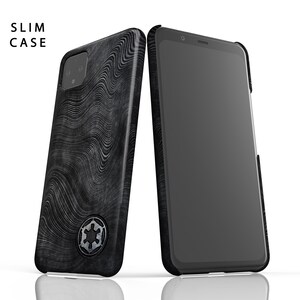 Puede incluir: Una funda de tel&eacute;fono negra con un patr&oacute;n ondulado y el s&iacute;mbolo imperial de Star Wars. La funda est&aacute; dise&ntilde;ada para adaptarse a un tel&eacute;fono delgado. La funda del tel&eacute;fono se muestra junto a un tel&eacute;fono negro.