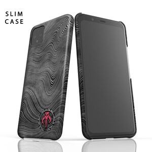 May include: Two black and gray slim phone cases with a wavy pattern. One case is leaning against a smartphone. The case features a red emblem with the text "THIS IS THE WAY". The text "SLIM CASE" is at the top left.