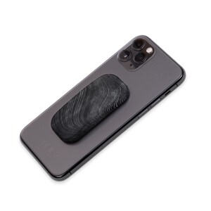 May include: A black phone with a black and white patterned phone grip attached to the back.