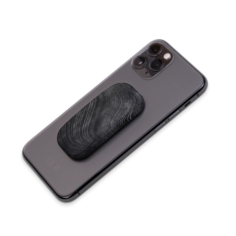 May include: A black phone with a black and white patterned phone grip attached to the back.