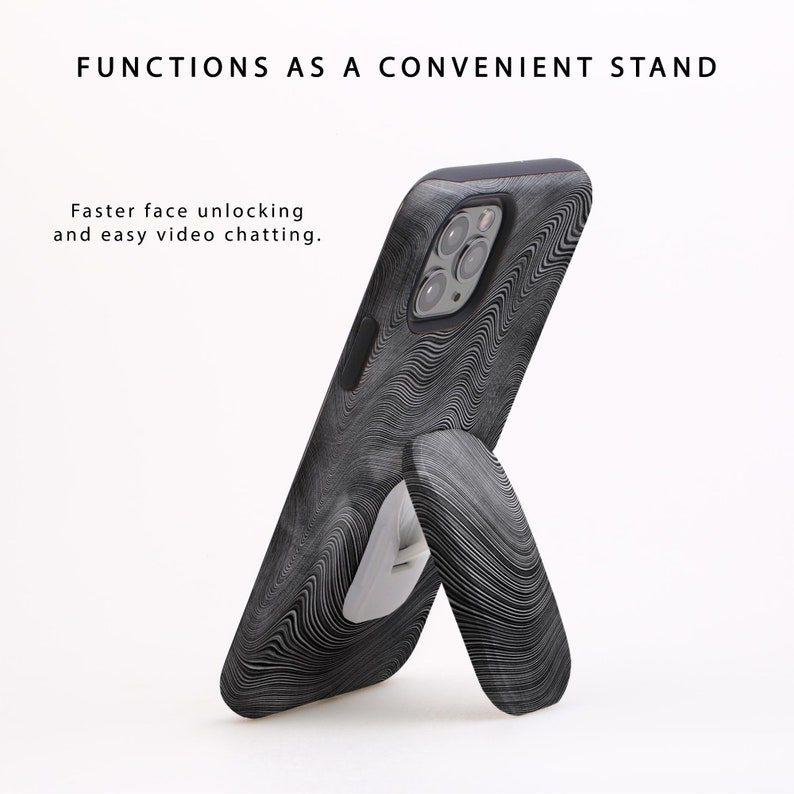 Puede incluir: Una funda de tel&eacute;fono negra con un patr&oacute;n de remolino blanco y negro. La funda tiene un soporte integrado que permite que el tel&eacute;fono se mantenga en posici&oacute;n vertical.