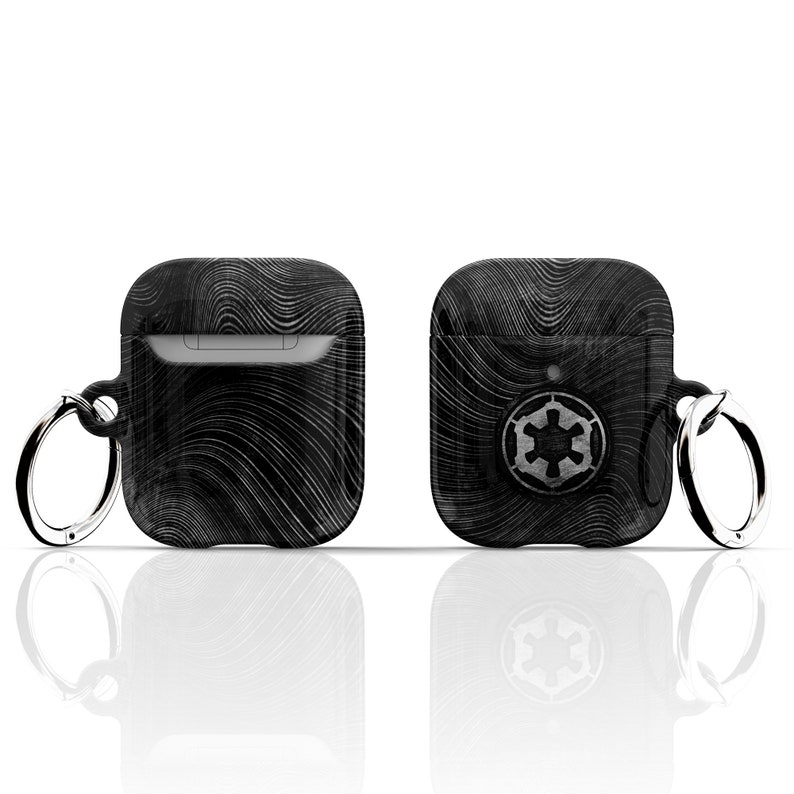 May include: Black Airpods case with a black and white wavy pattern and a silver Imperial symbol on the front. The case has a silver ring attached to it.